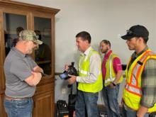Don Scarsella, Owens Corning environmental leader, consults with three other men.